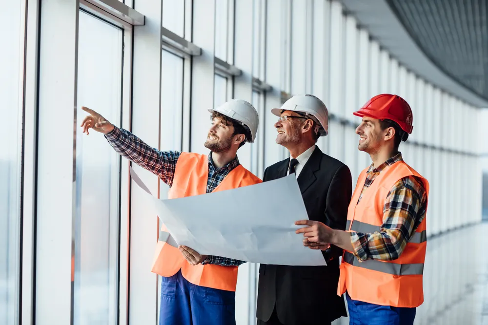 Der Architekt zeigt dem Vorarbeiter das Projekt seines Kollegen.